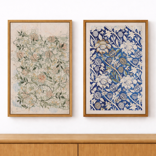 Two floral framed artworks on a white wall above a wooden cabinet.