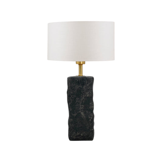 Table lamp with a textured black base and white shade on a white background