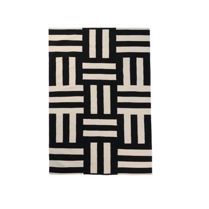 A black and cream colored geometric pattern area rug.