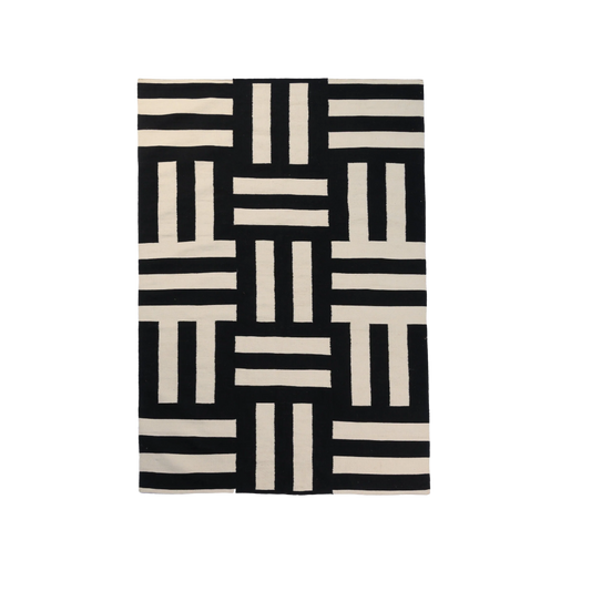 A black and cream colored geometric pattern area rug.